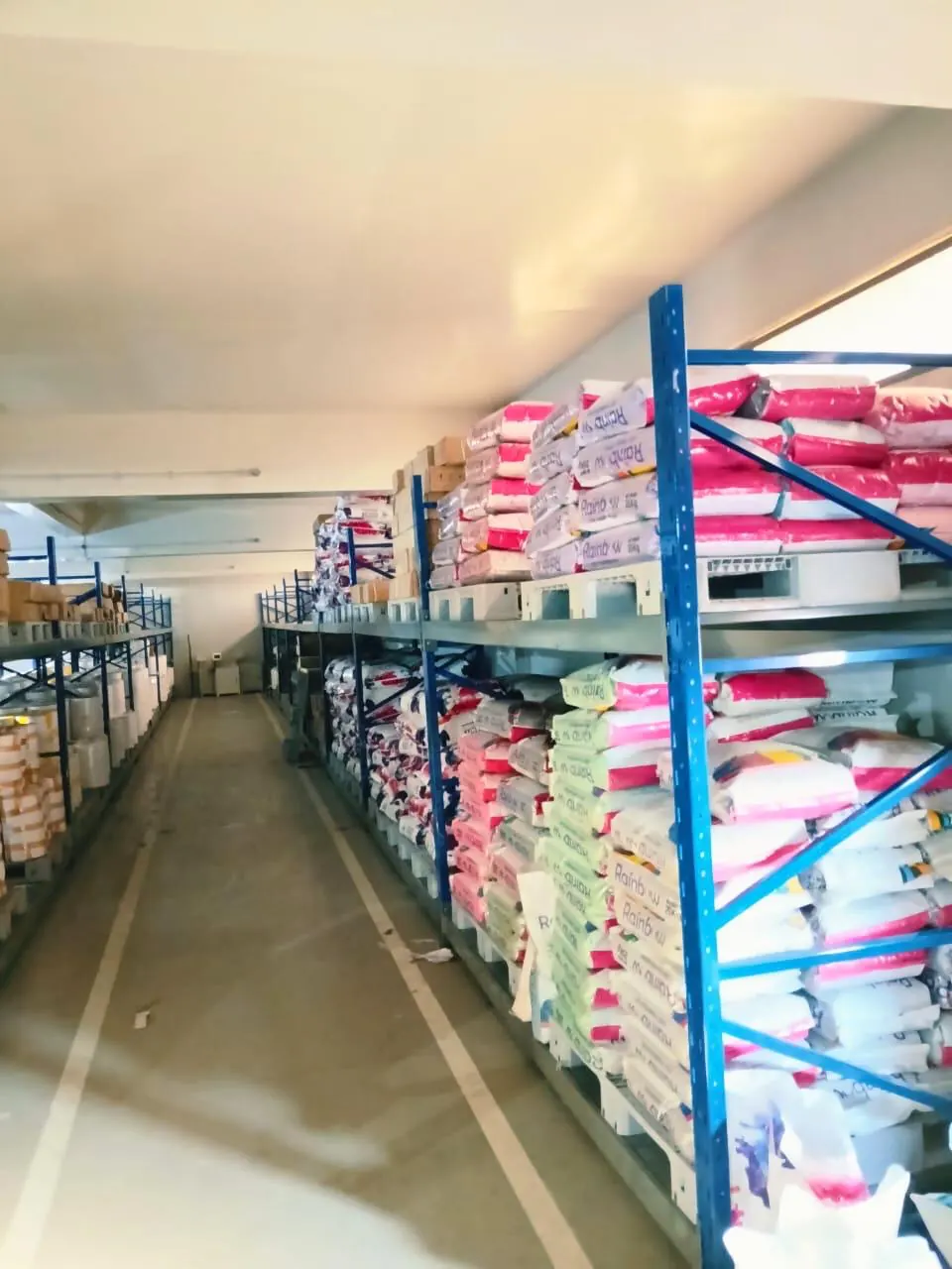 Stocked racking running the length of a godown aisle